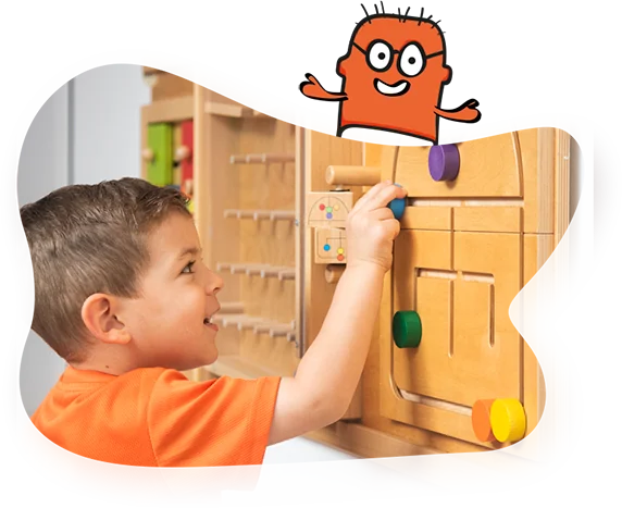 Niño explorando un panel de actividades de madera en Chikitopia